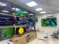 Smart TV display wall inside the Super Sales & Services showroom in Surat.
