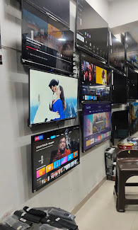 Smart TV display wall inside the Super Sales & Services showroom in Surat.