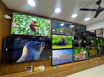 Smart TV display wall inside the Super Sales & Services showroom in Surat.